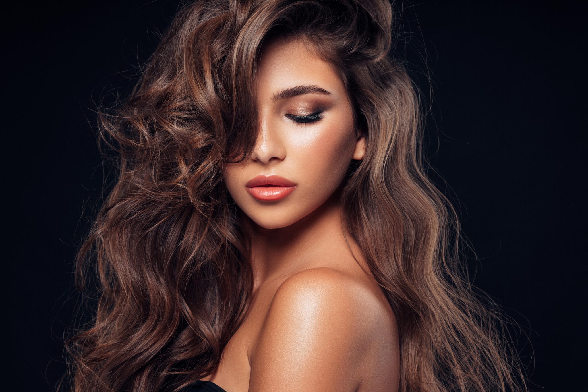 woman with long black hair bright makeup isolated on black